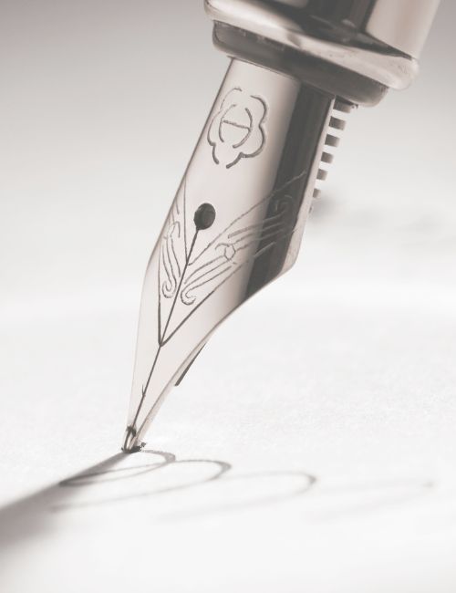 Close up image of the tip of a fountain pen writing on paper
